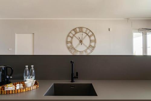 a clock on the wall above a kitchen sink at Palazzo Verdi Luxury Accomodation in Bari