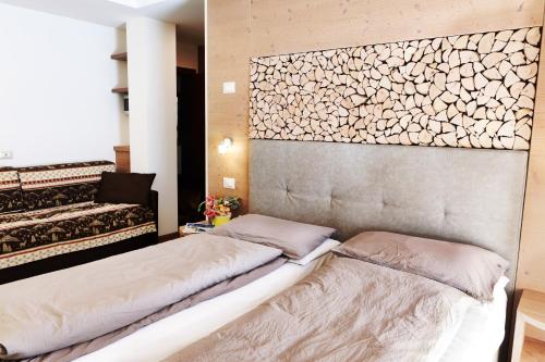 una camera con due letti e una parete di Hotel Wanda a Pinzolo