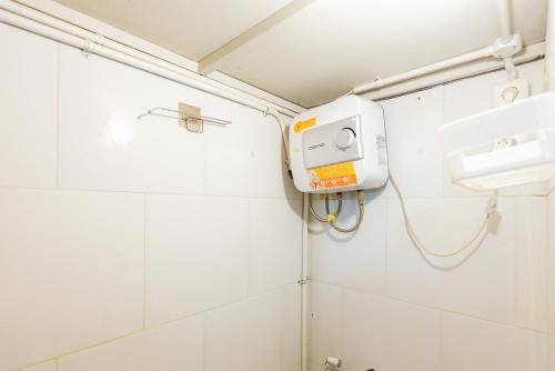 ein Bad mit einer weiß gefliesten Wand und einem Waschbecken in der Unterkunft RedDoorz At Stariez Kemang in Jakarta