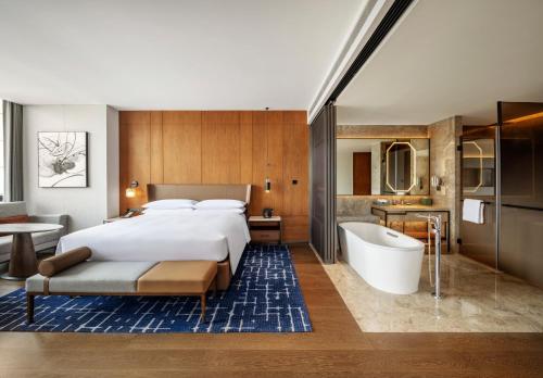 a hotel room with a bed and a bath tub at Sheraton Xuzhou in Xuzhou