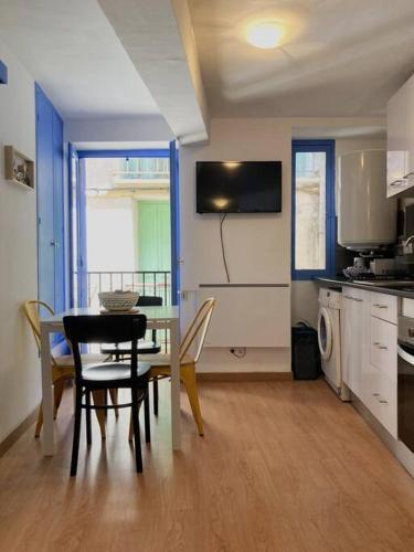 une cuisine et une salle à manger avec une table et des chaises dans l'établissement Maisonnette à deux pas de la plage., à Collioure