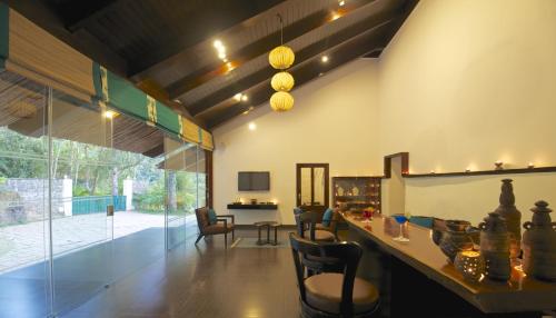 a living room with a table and chairs at Niraamaya Retreats Cardamom Club in Thekkady