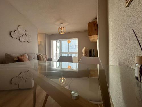 - un salon avec une table en verre et un canapé dans l'établissement Apartamento La Concha PLAYA DE LEVANTE, à Benidorm
