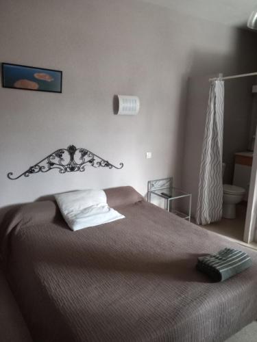 um quarto com uma cama com uma colcha castanha em Hotel bar Restaurant O REGAL em Villeneuve-sur-Lot