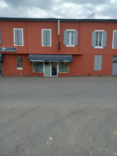 an orange building with an empty parking lot in front at Hotel bar Restaurant O REGAL in Villeneuve-sur-Lot