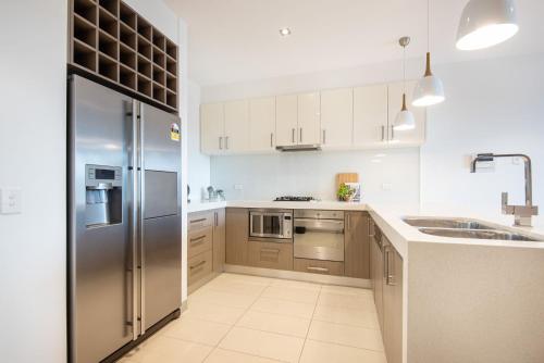 a kitchen with a stainless steel refrigerator and a sink at Aqua Views of the bay in Mornington in Mornington