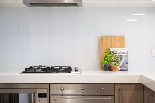 a kitchen with a stove top oven next to a counter at Aqua Views of the bay in Mornington in Mornington