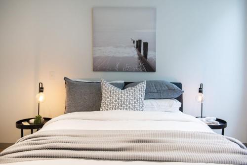 um quarto com uma cama e um quadro na parede em Luxe on Main in Mornington Views of the Bay em Mornington