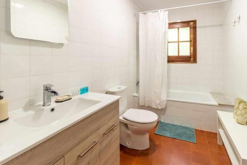 biała łazienka z toaletą i umywalką w obiekcie M de Puigsec Mas rural al Ripollès w mieście Girona