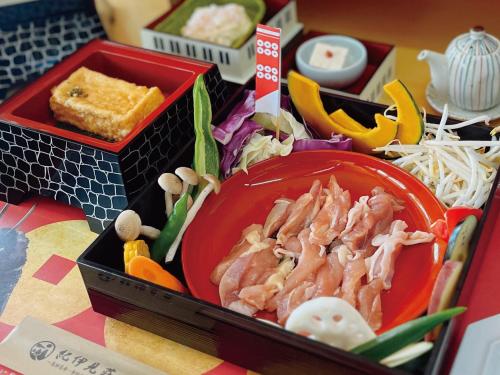a lunch box with a plate of food and noodles at 真田昌幸-幸村父子の隠れ宿 紀伊見荘 in Hashimoto