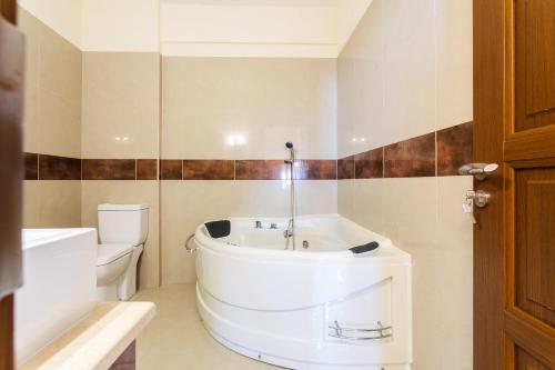 a bathroom with a white tub and a toilet at Villa Armonia, Sunset View and Relaxing Beach Vibe in Proástion