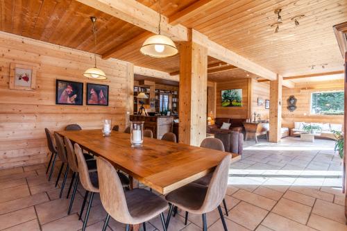 une salle à manger avec une table et des chaises en bois dans l'établissement chalet les ecureuils, à Saint-Jean-de-Sixt