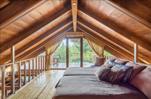 a large bed in a room with a wooden ceiling at Turdus Merula Retreat in Nea Makri