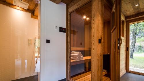 Cette chambre dispose d'une porte en verre et d'un miroir. dans l'établissement Chalet Rass, à Chamonix-Mont-Blanc