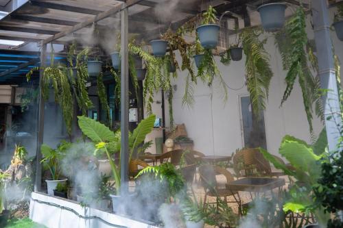 a restaurant with plants hanging from the ceiling at Blue Carina Hotel Phuket in Phuket Town