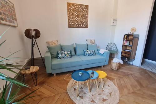 a living room with a blue couch and a table at L'Escapade Bohême in Vienne