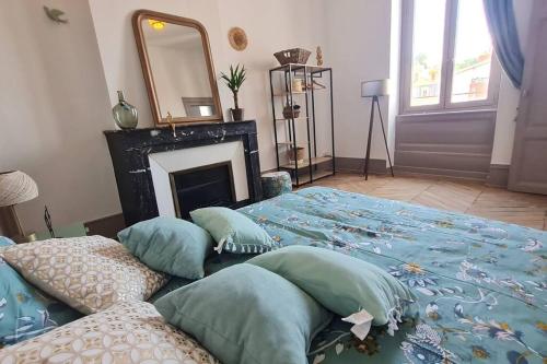 a bedroom with a bed with a fireplace and a mirror at L'Escapade Bohême in Vienne