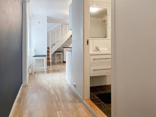 a kitchen with white cabinets and a hallway with a staircase at Unique Nest Central Near Sea in Stavanger