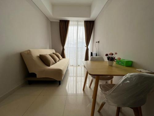 sala de estar con sofá, mesa y silla en 2BR 36 Taman Anggrek Residence Best Cozy and Stay Wifi 50mbps and Netflix Provided, en Yakarta