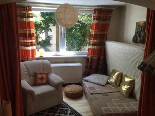 a living room with a chair and a window at Haus KAIROS in Spittal an der Drau
