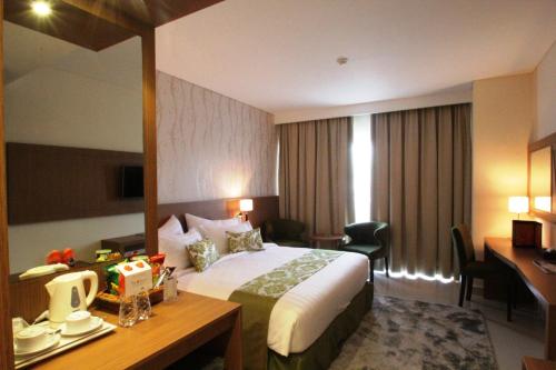 a hotel room with a bed and a desk and a desk at Ijen Suites Resort & Convention in Malang