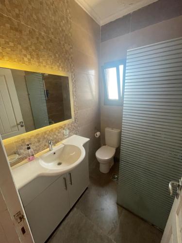 bagno con lavandino, servizi igienici e specchio di Lahacienda Two bedroom chalet with roof a Ras Sedr