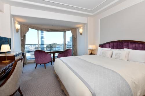 a hotel room with a large bed and a desk at Hotel New Grand in Yokohama