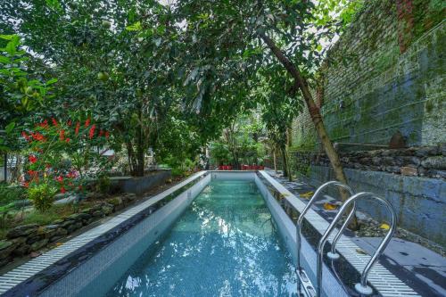 een zwembad in een tuin met bomen bij Summit Bougainvillea Tea Resort in Kurseong