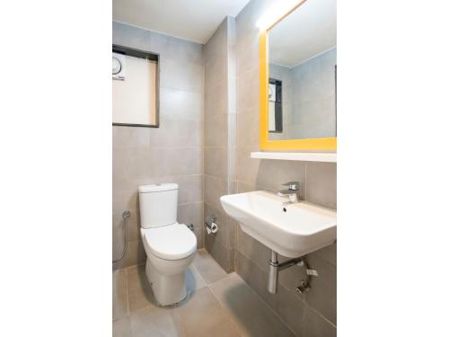 a bathroom with a toilet and a sink at Bloom Hotel - HSR Club in Bengaluru
