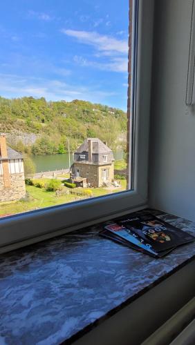 a window with a view of a house and water at Le Revella in Profondeville