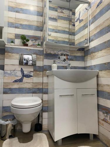 a bathroom with a white toilet and a sink at Apartament A&A Hațeg in Haţeg