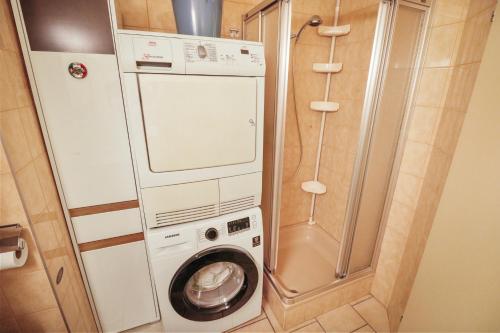 - un lave-linge et un sèche-linge dans une petite salle de bains dans l'établissement Super appartement au coeur de Martigny, à Martigny-Ville