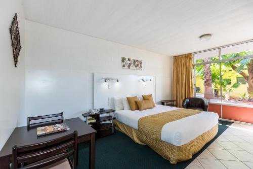 a hotel room with a bed and a desk at Elkira Court Motel in Alice Springs
