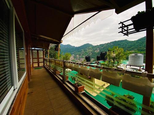 a balcony of a house with a view of the mountains at Aman The Lake Side Hotel in Nainital