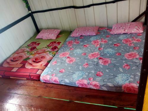 Bett in einem Zimmer mit rosa Rosen in der Unterkunft Kelong Bintan in Teluk Bakau