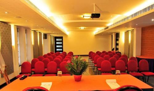 a conference room with red chairs and a table at Copper Folia in Kozhikode