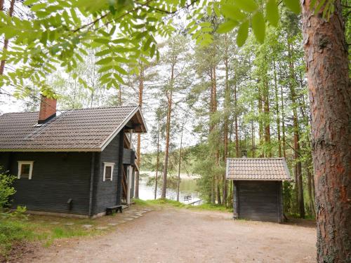 una casa pequeña y un garaje en el bosque en Mökki Aapola, en Puumala
