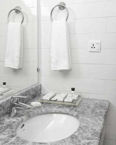 a bathroom with a sink and a mirror and towels at Faletti's Express- Shimla Hill in Lahore
