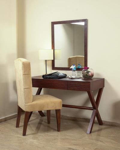 a wooden desk with a mirror and a chair at Faletti's Express- Shimla Hill in Lahore