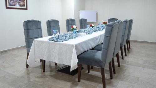 a long table with blue chairs and a white table cloth at Faletti's Express- Shimla Hill in Lahore