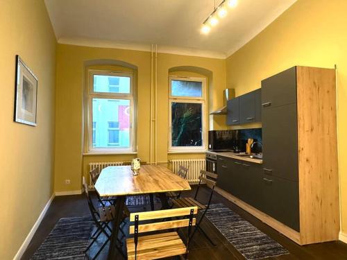una cucina con tavolo in legno e frigorifero di Schönes großes Apartment im Zentrum Berlins a Berlino