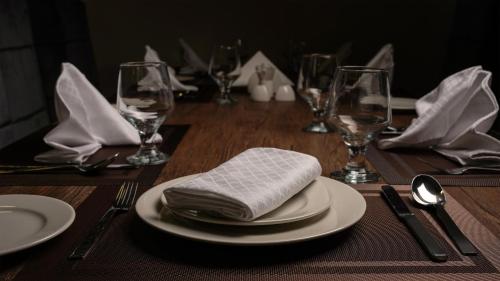 a wooden table with a table set with plates and napkins at Faletti's Express- Shimla Hill in Lahore