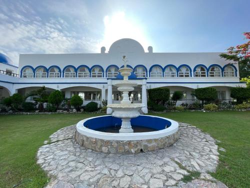 a fountain in front of a large building at Torres Farm Resort powered by Cocotel in Naic