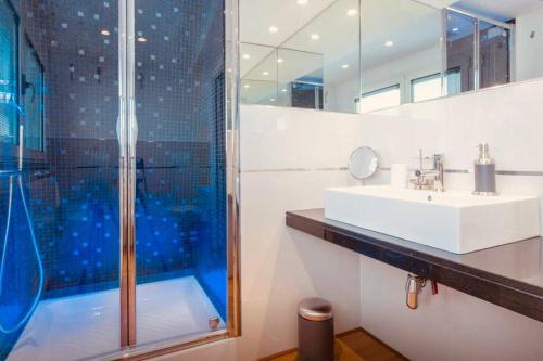 een badkamer met een wastafel en een douche bij Luxury Penthouse Aranova in Aranova