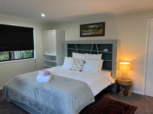 1 dormitorio con 1 cama grande y TV de pantalla plana en Hillside Retreat Guest House, en Bli Bli