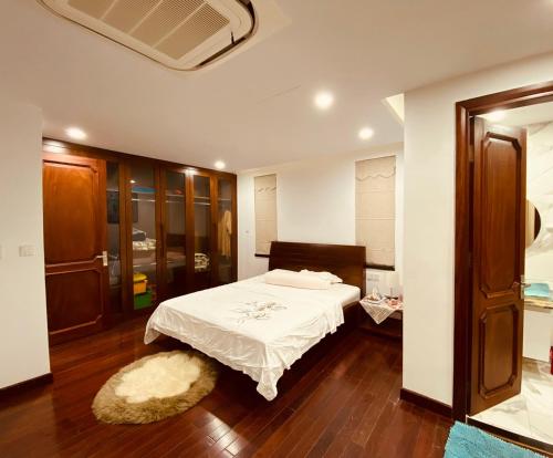 a bedroom with a bed with a white sheets and a rug at An Villa Venuestay in Tam Ðảo