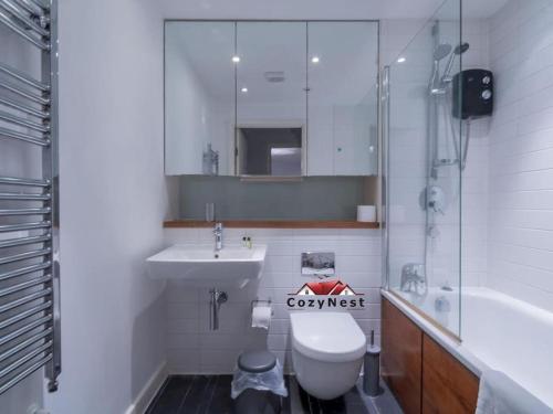 a bathroom with a toilet and a sink and a mirror at Elegant Central Self Contained Flat by CozyNest. in Reading