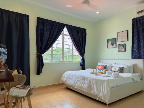 a bedroom with a bed with blue curtains and a window at NewWALAI N3 Landed house near IMAGO KK with CarGarage in Kota Kinabalu