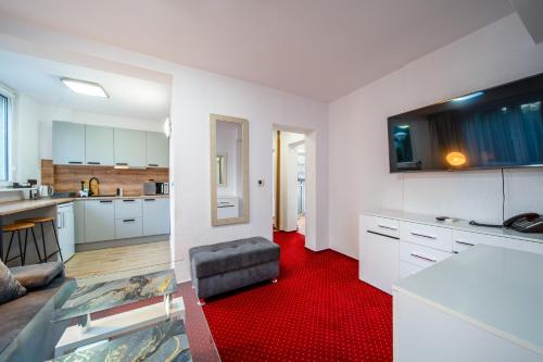 a kitchen with white cabinets and a red carpet at Apartament Gromada Babimojska in Poznań