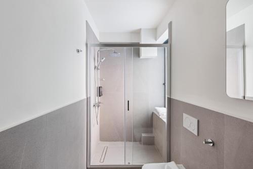 a bathroom with a glass shower with a toilet at Airio Athens Suites in Athens